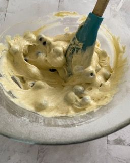 Una ciotola di glassa con una spatola dentro.