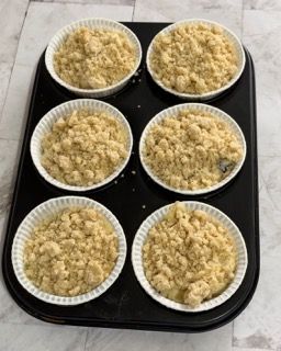 Uno stampo per muffin riempito con sei tazze di briciole di copertura