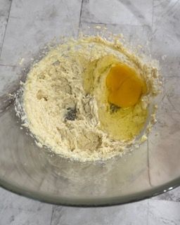 Un uovo viene aggiunto a una ciotola di pastella.