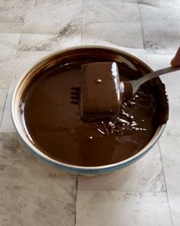 Una tavoletta di cioccolato viene immersa in una ciotola di salsa al cioccolato