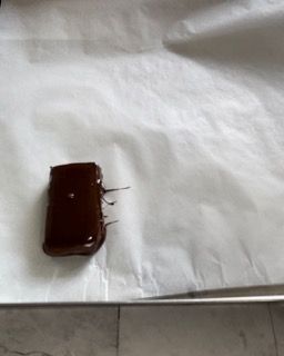 Un pezzo di cioccolato è appoggiato su un pezzo di carta oleata.
