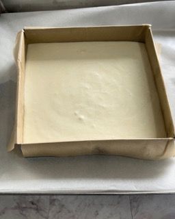 Una scatola di cartone piena di una sostanza bianca è appoggiata su un tavolo.