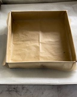 Una scatola marrone è appoggiata su un tavolo bianco.