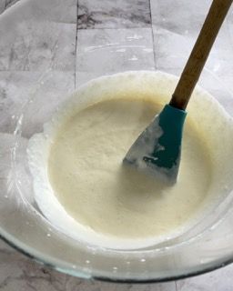 Una ciotola di liquido bianco con una spatola dentro.