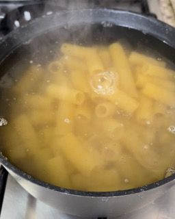 La pasta viene cotta in una pentola con acqua sul fornello.