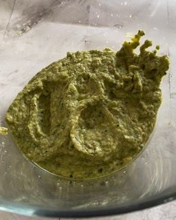 Un primo piano di una salsa verde in una ciotola di vetro