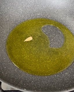 Primo piano di una padella piena di olio e aglio.