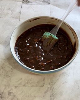 Una ciotola di salsa al cioccolato con una spatola verde dentro