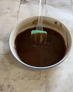 Una ciotola di salsa al cioccolato con una spatola dentro