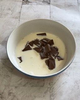 Una ciotola di latte e cioccolato su un tavolo.