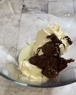 Una ciotola di vetro piena di cioccolato e panna montata