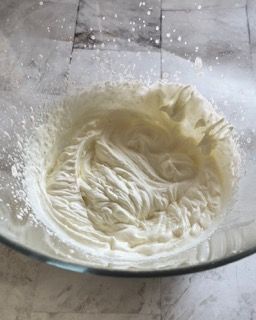 Una ciotola di panna montata è appoggiata su un tavolo.