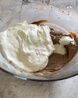 Una ciotola di vetro piena di cioccolato e panna montata