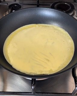 Un pancake sta cuocendo in una padella sul fornello