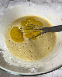 Una ciotola di liquido con una frusta dentro.