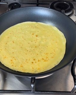 Un pancake sta cuocendo in una padella sul fornello