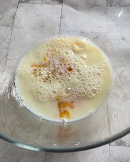 Un primo piano di una ciotola di latte e uova su un tavolo.