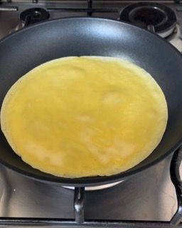 Un pancake sta cuocendo in una padella sul fornello