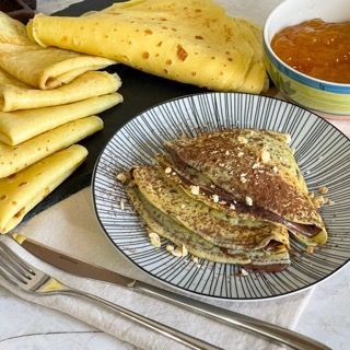 Un piatto di pancake accanto a una ciotola di marmellata