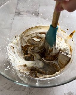 Una persona sta mescolando qualcosa in una ciotola con una spatola.