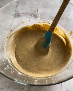 Una ciotola di salsa con una spatola blu dentro