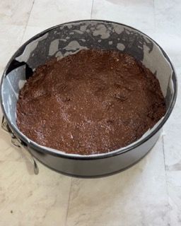 Una padella piena di impasto per brownie è appoggiata su un tavolo.