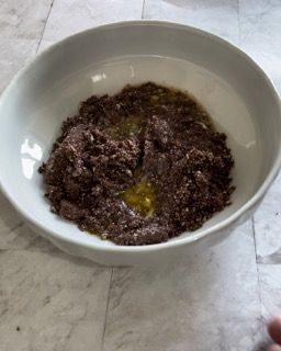 Una ciotola bianca piena di una sostanza marrone su un tavolo