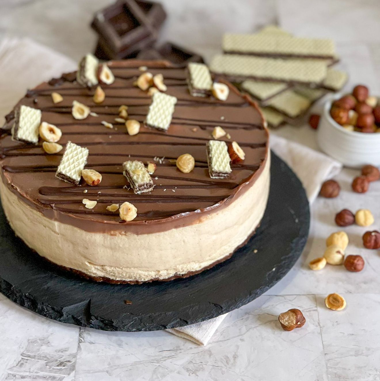 Una torta al cioccolato con sopra delle noci è su un piatto nero