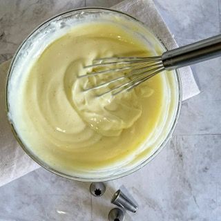 Una ciotola di glassa con dentro una frusta