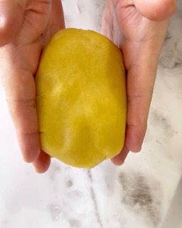 Una persona tiene in mano una piccola pallina gialla.