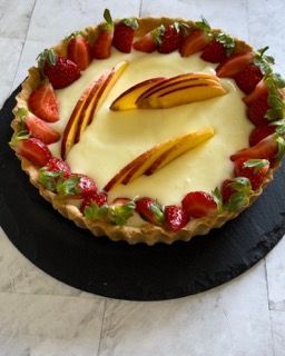 Una torta con fragole e pesche sopra