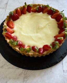 Una torta con fragole e panna montata sopra