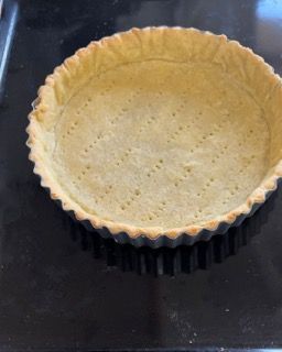 Una crosta di torta è appoggiata su un tavolo nero