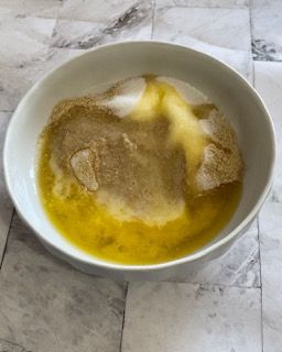 Una ciotola bianca piena di un mix di ingredienti su un tavolo.