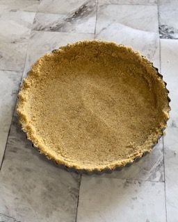 Una crosta di torta è appoggiata su una superficie di marmo.