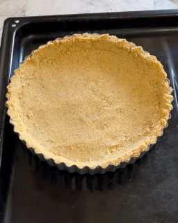 Una crosta di torta è appoggiata su una padella nera