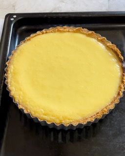 Una torta gialla è appoggiata su una padella nera.