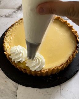 Una persona sta glassando una torta con panna montata