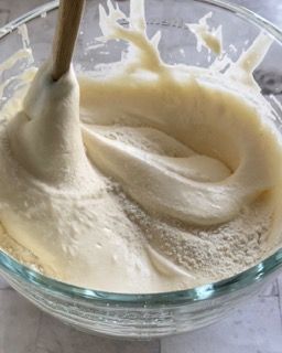 Una ciotola di pastella con un cucchiaio di legno dentro.