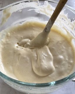 Una ciotola di pastella con un cucchiaio di legno dentro.