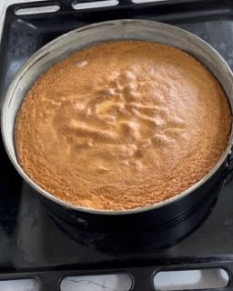 Una torta in una teglia è appoggiata sopra un fornello.