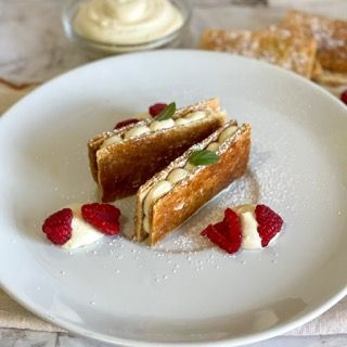 Un piatto bianco sormontato da due panini e lamponi