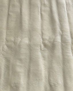 Un primo piano di un tessuto bianco con un motivo a strisce.