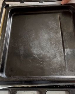 Un vassoio nero è appoggiato sopra una stufa.