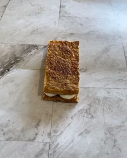 Un pezzo di torta è appoggiato su un pavimento piastrellato