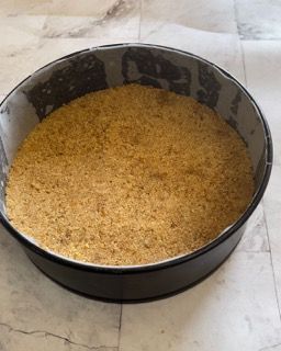 Una padella piena di briciole è appoggiata su un tavolo