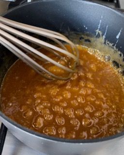 Una pentola di salsa con dentro una frusta