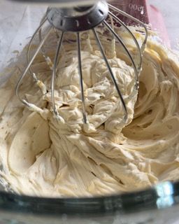 Un primo piano di un mixer con panna montata al suo interno.