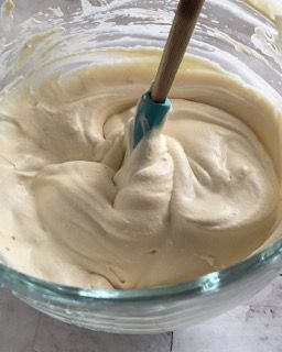 Una ciotola di panna montata con una spatola dentro.