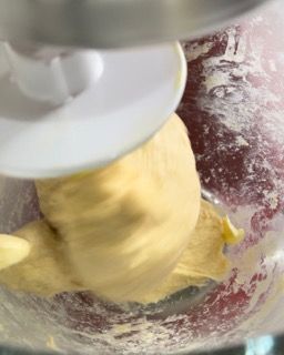 Primo piano di un'impastatrice che mescola un impasto in una ciotola.